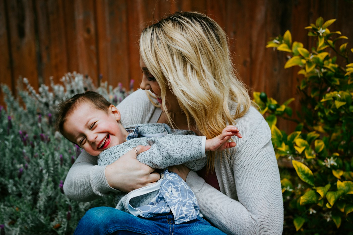 Self-employed nanny carrying a young girl outdoors