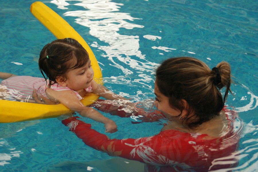 Swimming instructor teaching a child in the pool